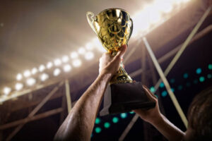 Athlete holding trophy cup above head in stadium